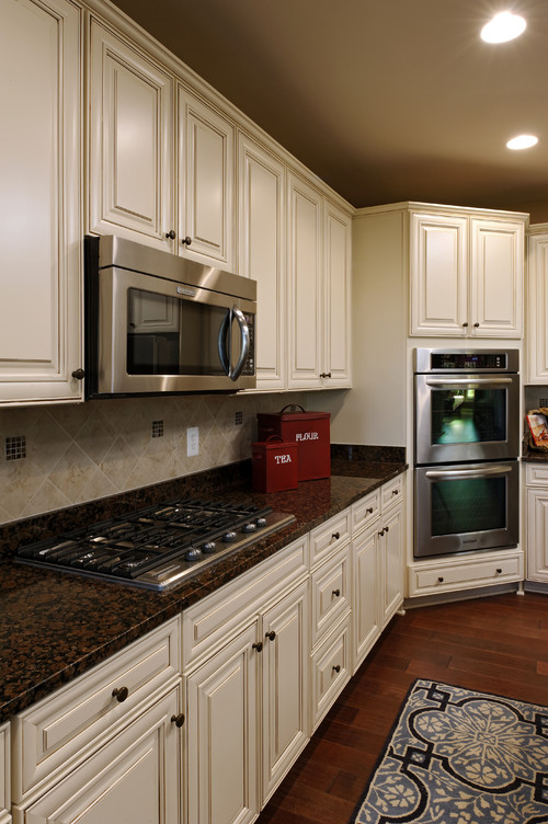 Baltic Brown Granite Countertop with Sierra Vista Painted Hazelnut Glazed Maple Cabinets, Beige Diagonal Set Up Ceramic Backsplash, Maple Hardwood Flooring and Stainless Steel Appliance